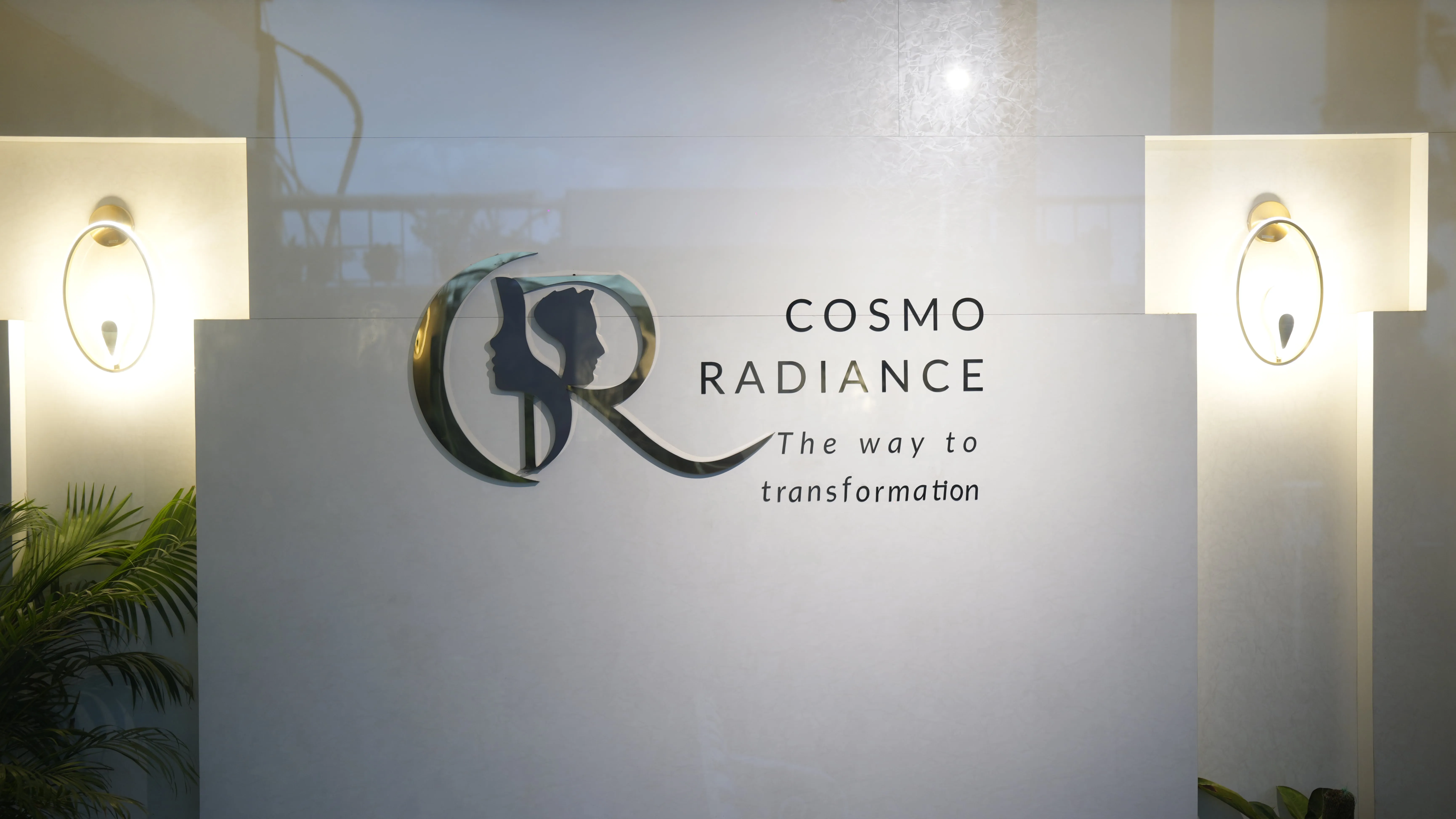 Illuminated Cosmo Radiance logo mounted on a pristine white wall