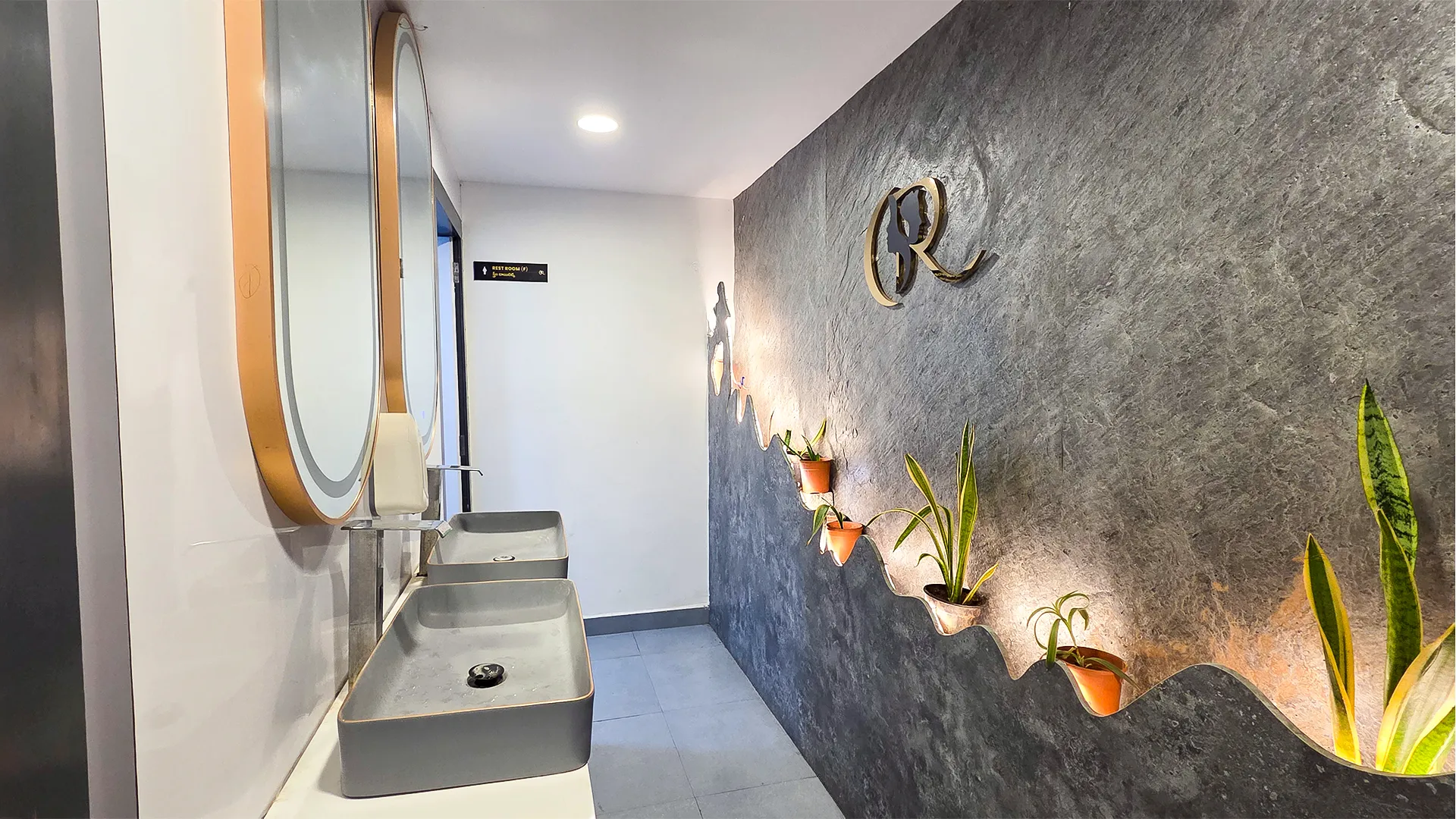 Luxury gender-neutral washroom with stone cladding